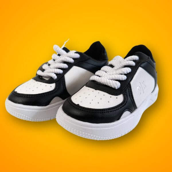 Tenis para niña en color blanco con detalles en negro que combinan con cualquier outfit.